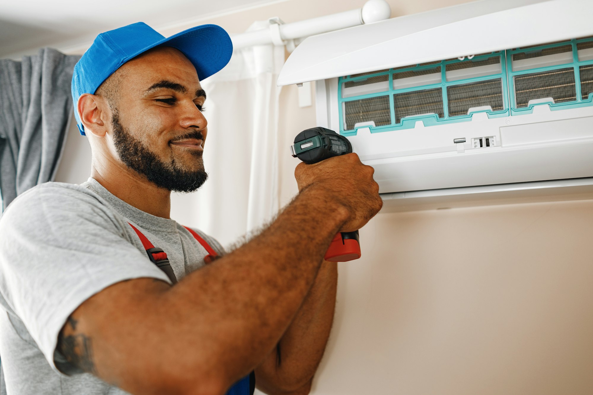 Professional repairman installing air conditioner in a room